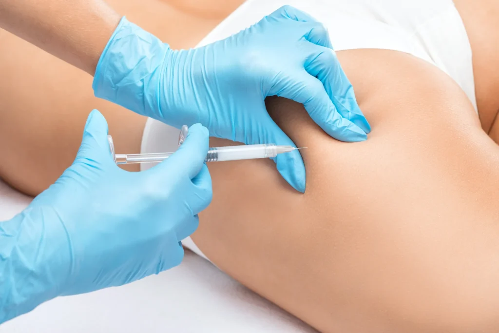 A person receiving a fat dissolving treatment, with a healthcare professional administering the injection in the hips.